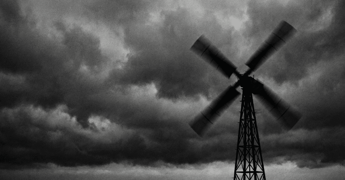 Historic windmill in motion against dark storm clouds.